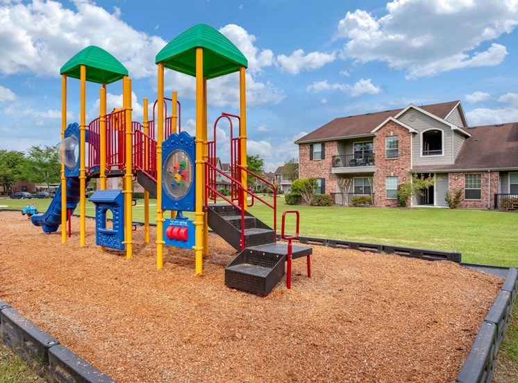 Colorful Playground  on Mulch with Building Exteriors in the Background